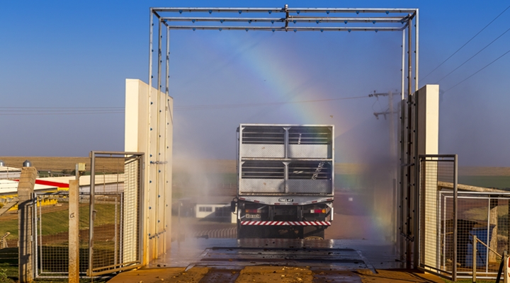 a imagem mostra um caminhão sendo desinfectado para entrar na granja, por conta das medidas de biossegurança