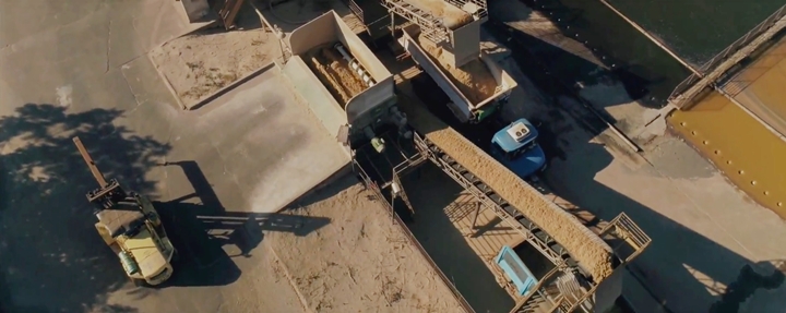 Foto que ilustra os ingredientes inclusos através de pás carregadeiras ou esteiras automáticas,